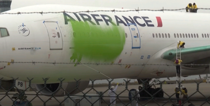 Активисты Greenpeace в знак протеста раскрасили припаркованный самолет Air France в зеленый цвет