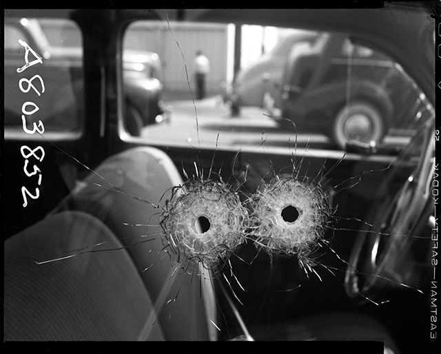 Detail of two bullet holes in car window Date: 10/10/1942 Photographer: Unknown